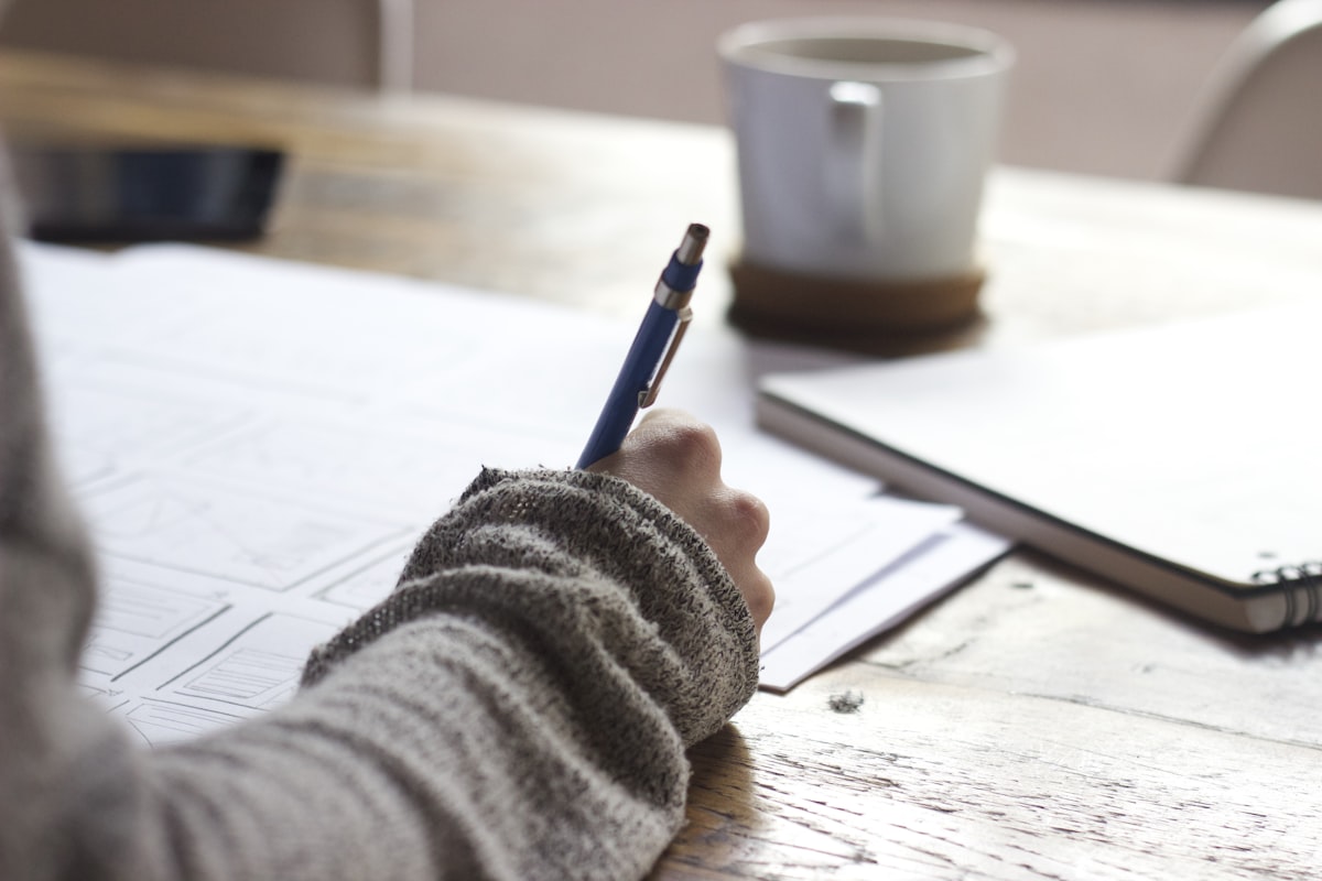 A writer editing a document on a laptop with notes nearby