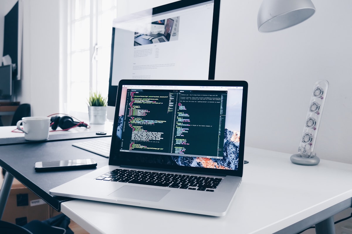 A laptop screen showing lines of code in a dim workspace