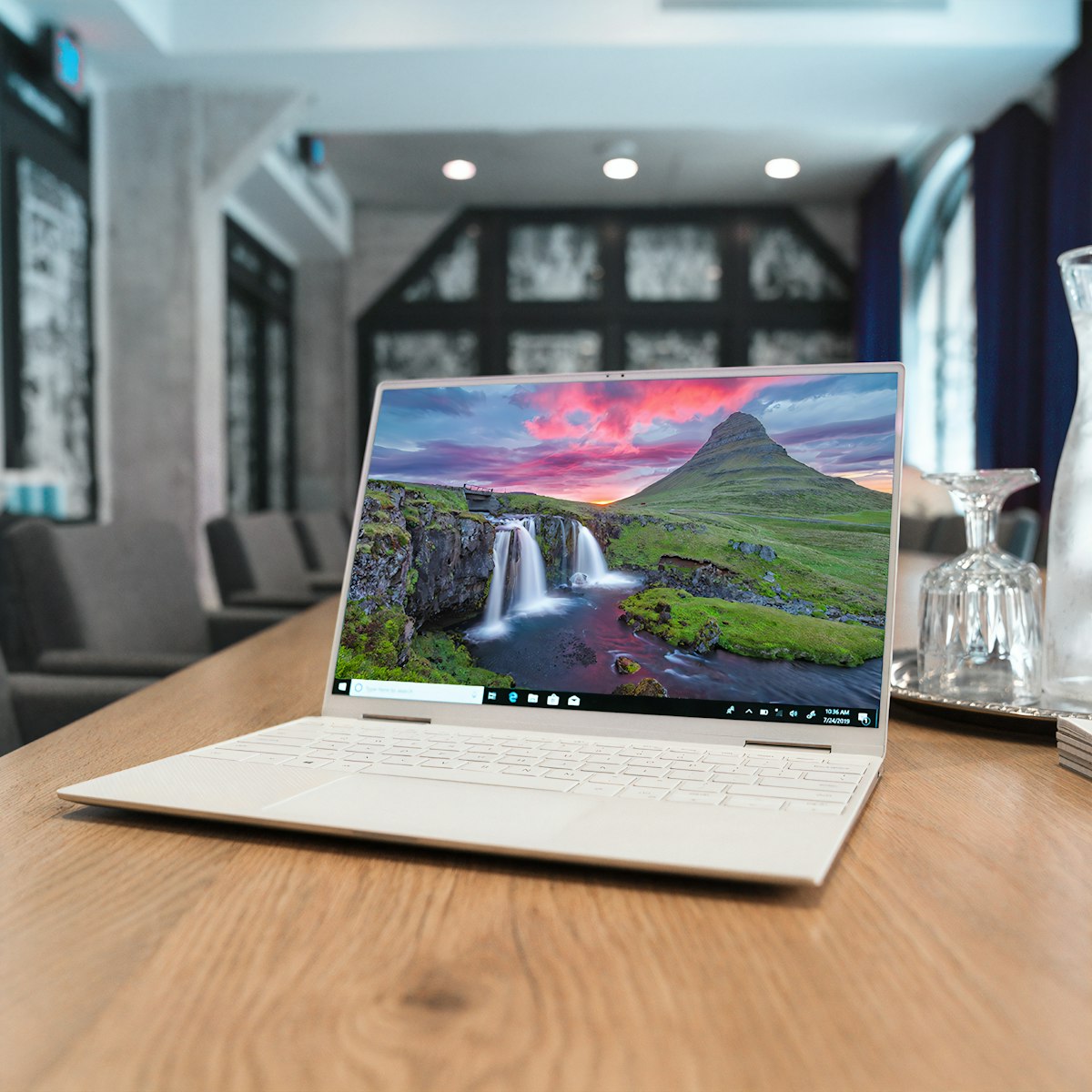 A laptop on a plain background with a wireless mouse beside it